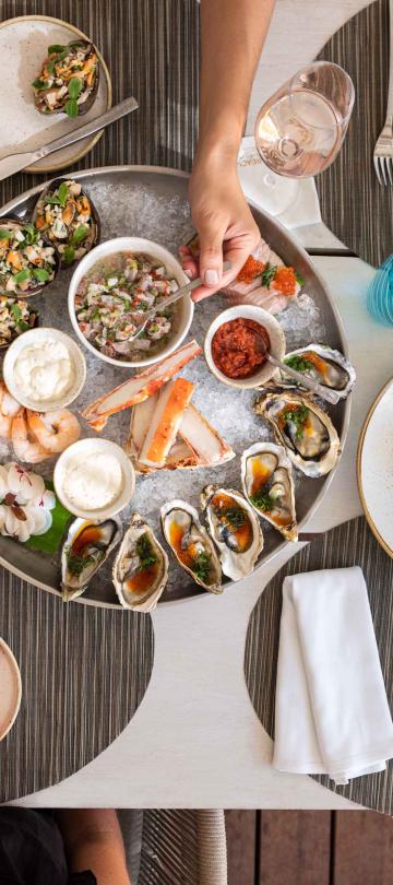 An overhead view of a spread of dishes and drinks from Jalousie Grill