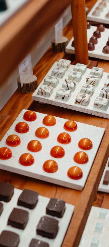 Uma vitrina com chocolates castanhos e laranja