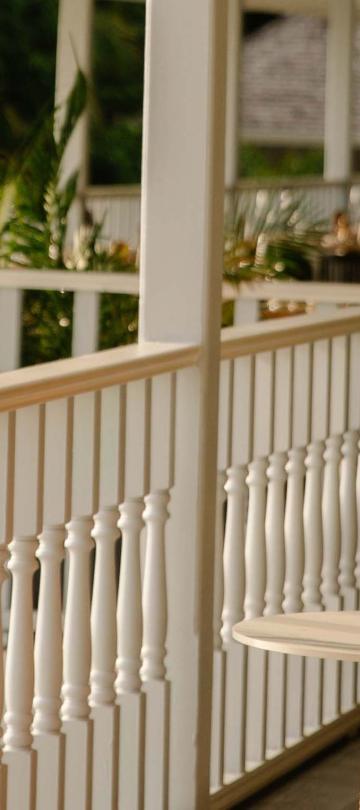 A woman drinking a tropical drink on a balcony