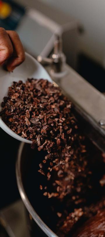 Flakes of cocoa being poured into a mixer