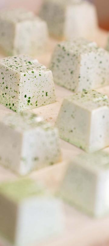 A row of chocolates with a white and green finish from Cocoa Mill