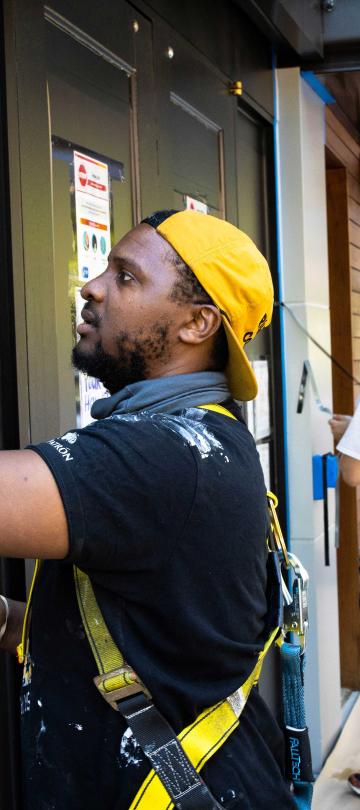 A No Kings Collective artist installs details  \on the exterior of Viceroy Washington DC