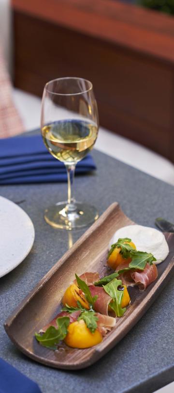 An elegant salad dish accompanied by a glass of wine on a table at BPM