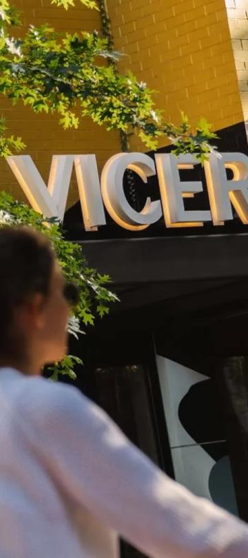 A woman rides her bike past the entrance of Viceroy Washington DC
