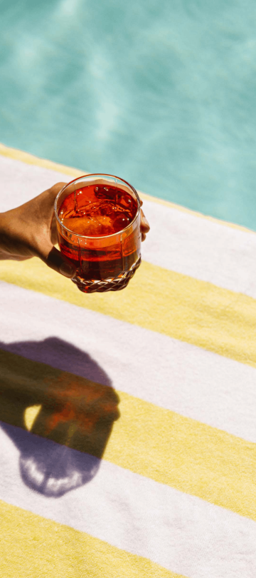An arm holding a cocktail poolside at Viceroy Washington