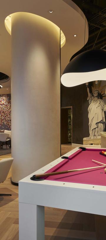 A pink pool table at Hotel Zena's Figleaf restaurant with dining tables and the bar in the background