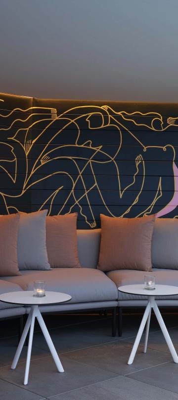 An intimate alcove with a semi-circle couch at Hedy's Rooftop