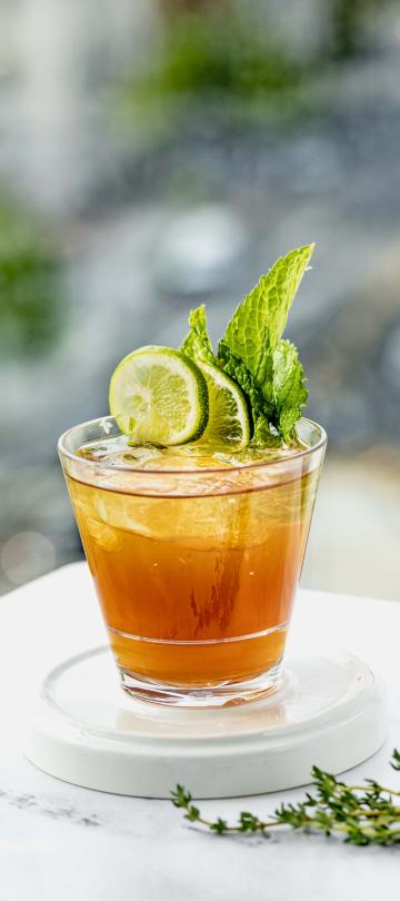 A citrus cocktail garnished with lime and mint