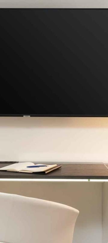 A desk area with a large TV above it in a room at Viceroy Zena Washington