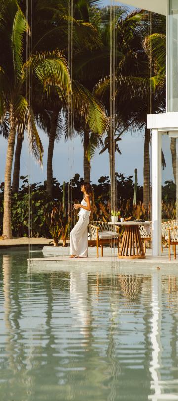 woman standing beside outdoor villa pool