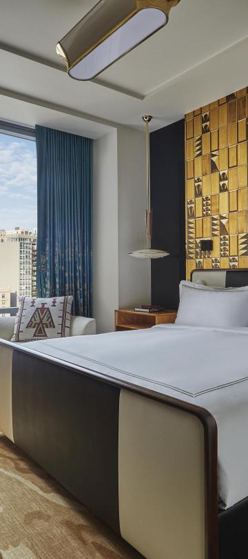 A king bed in a Viceroy Chicago hotel room with a City ciew