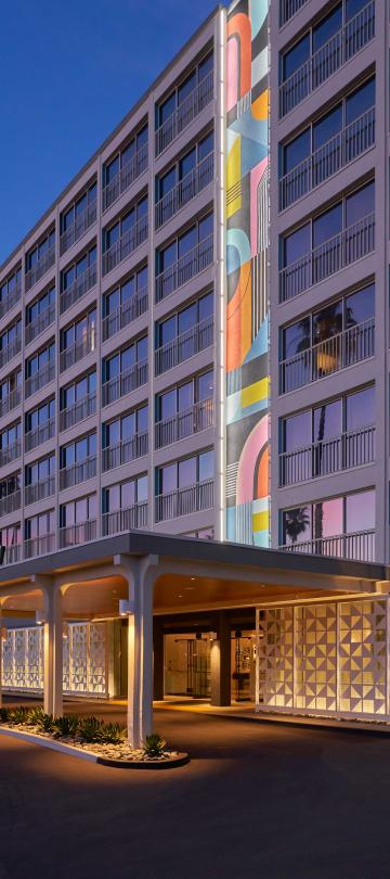 The exterior facade of Viceroy Santa Monica, with a large mural of kaleidoscopic colors