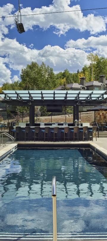 viceroy snomass pool with pool deck, and chairs