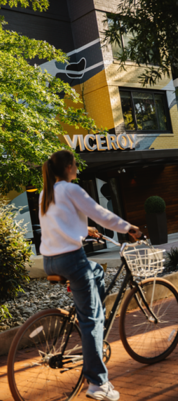 A woman on a bike rides outside the hotel.