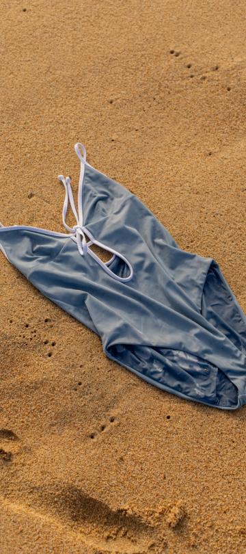 A one piece bathing suit on the beach.