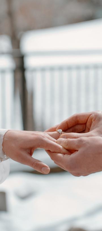 A groom putting on a ring on the brides finger