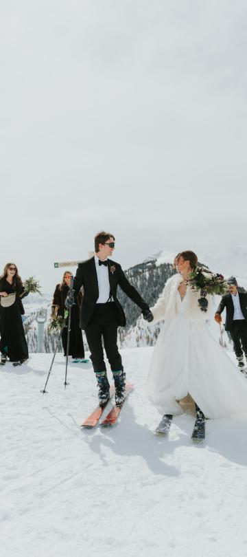 A bride and groom skiing in the snow