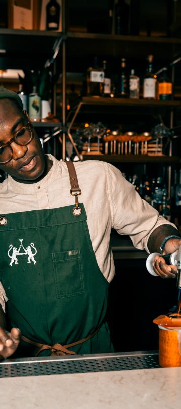 man making a drink at the bar