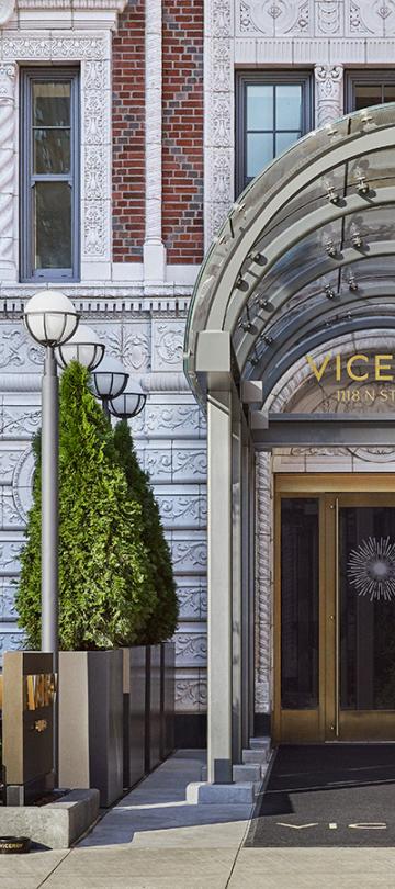 La entrada del hotel « Viceroy » cuenta con un porche acristalado con letras doradas y un diseño de rayos de sol en el cristal.