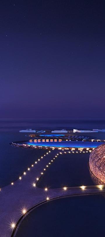 night view of a hotel surrounded by water