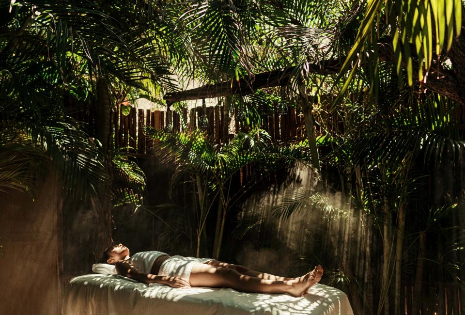 woman lays on treatment table in jungle
