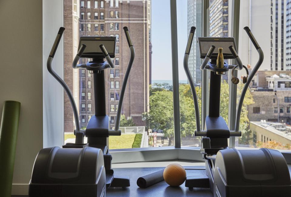 Two Elliptical exercise machines in front of a window with a view of the Chicago skyline