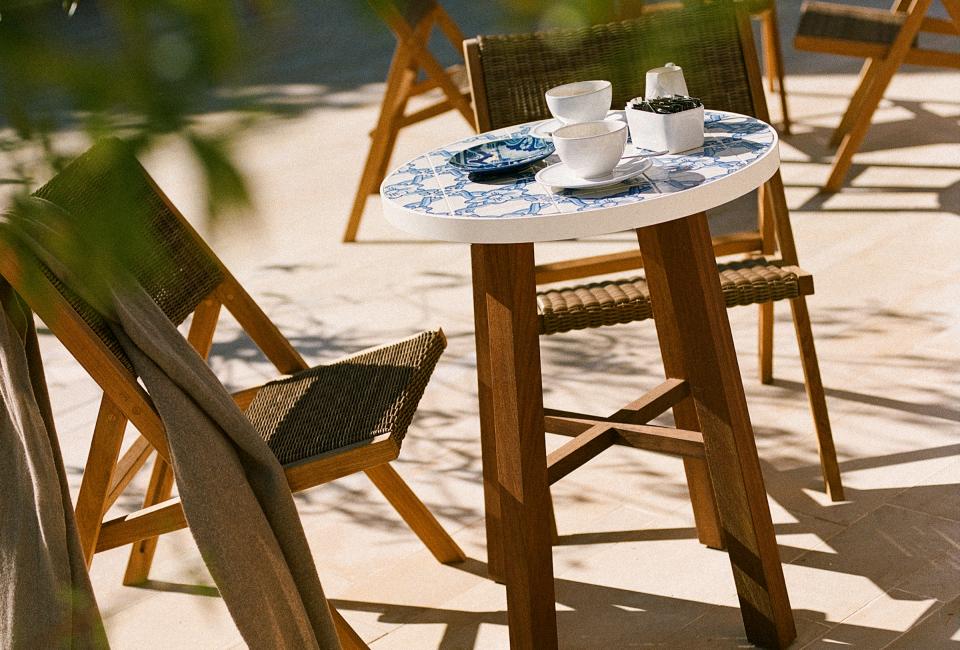A small round table and 2 chairs with coffee cups on top outside Cafe Central at Ombria Algarve