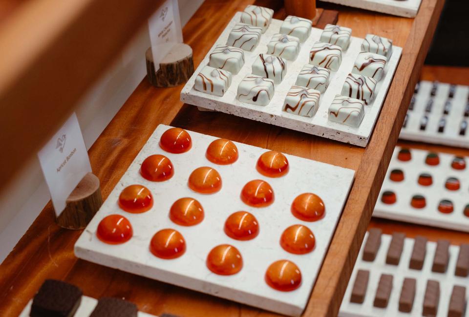 A display case of brown and orange chocolates