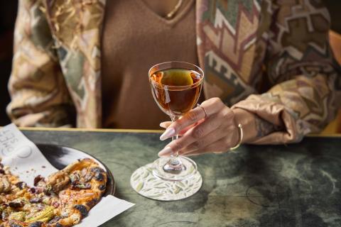 A woman holding a glass of whiskey