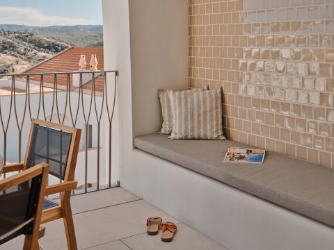 Balcony with long bench and dining area