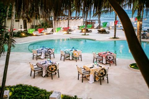 Dinner tables set up by the pool