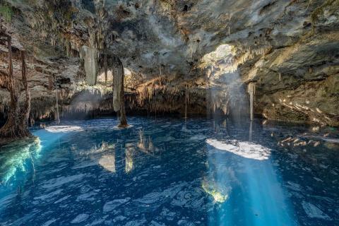 sunlight shining through a whole into the cenote