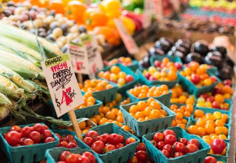 Bushels of tomatos at a stand at the farmers market