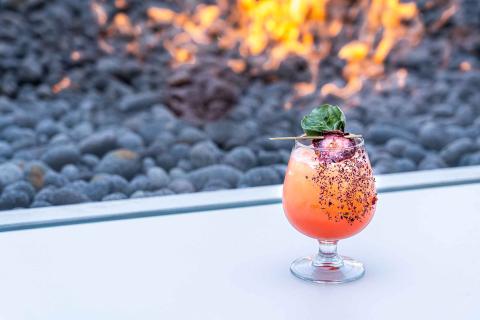 a cocktail with garnish resting on a table