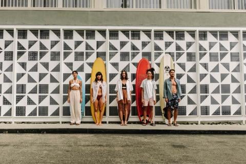 A group of friends standing in front of their surf boards