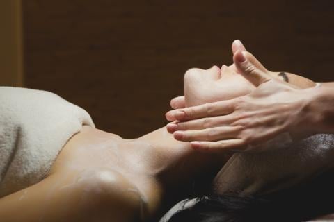 A person receiving a facial massage at Milk + Honey