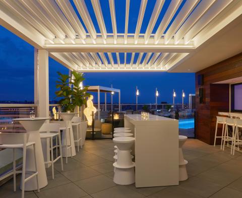 Hedy's Rooftop, a chic patio with heat lamps and a white lattice canopy, at night