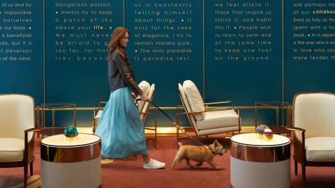 A woman walks her dog through the lobby of Viceroy Chicago