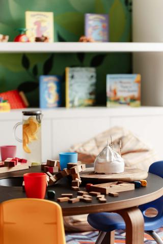 A kids playroom at Viceroy Kopaonik Serbia, with a table of blocks and fruit water and bookhelf in the background