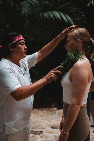 A man with sage healing a woman at Riviera Maya