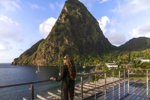 A woman standing on a balcony looking at the ocean at Spice of Life Residence