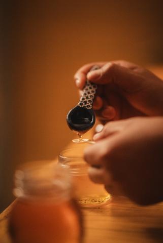 massage oil being ladled onto small spoon