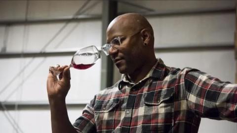 Sommelier André Mack smells a glass a red wine
