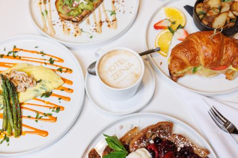 Brunch items from Figleaf, arranged on a table: Vanilla French Toast, Omelette, Avocado Toast, Croissant sandwich, and a latte.
