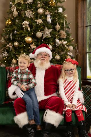 Two kids with Santa in front of a Christmas tree