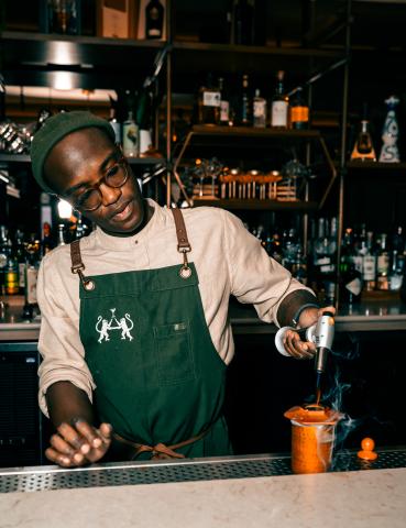 man making a drink at the bar