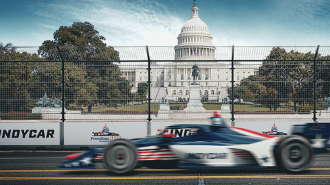 an Indy racecar driving past the US Capitol