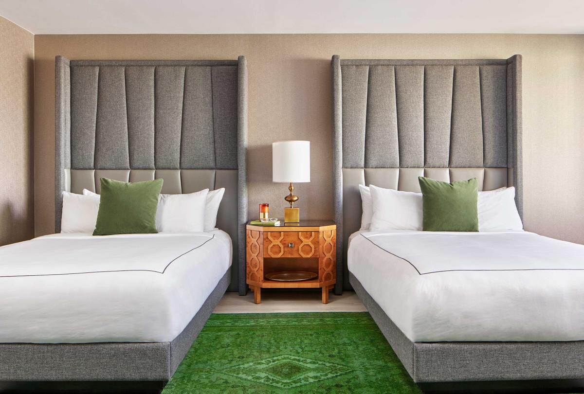 Bedroom with two queen beds and a large green carpet
