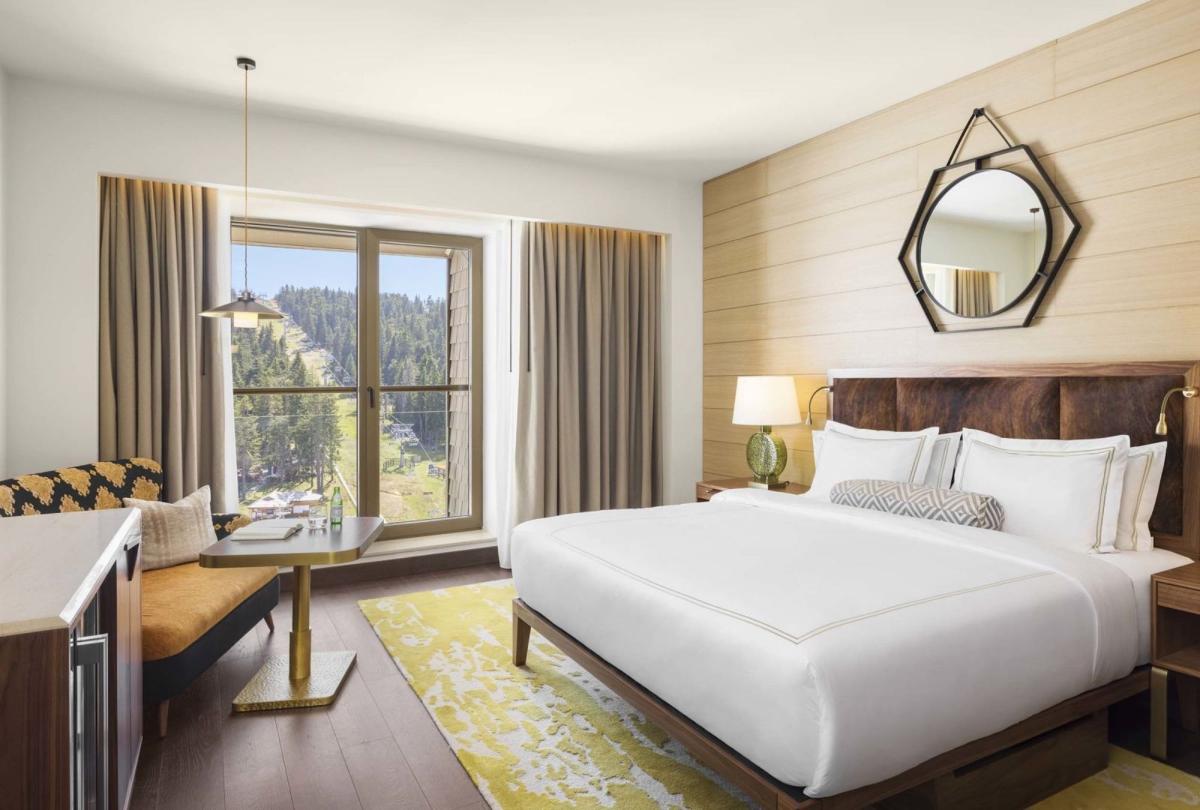 King room with a king bed, couch, dresser and tv at Viceroy Kopaonik Serbia