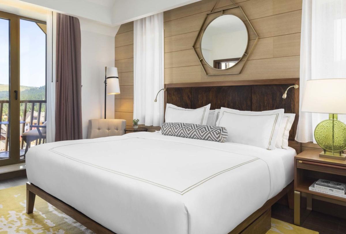 A king bed and balcony in a suite at Viceroy Kopaonik Serbia